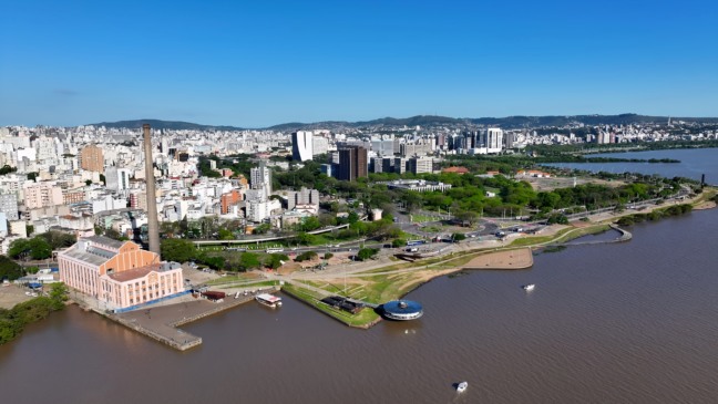 Vista aérea de Porto Alegre mostrando bairros residenciais e o Lago Guaíba ao fundo.
